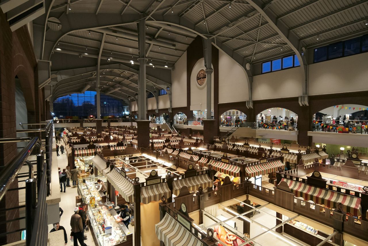 Diner enjoying food from multiple food court vendors