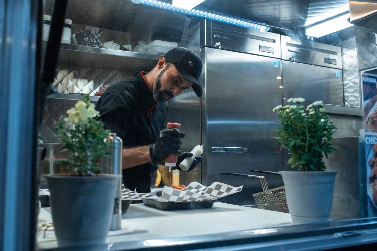 Vendor preparing an order for a food court diner